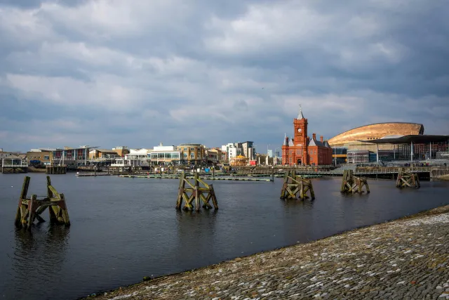 People walking along Cardiff Bay Barrage with the sea on one side and the bay on the other